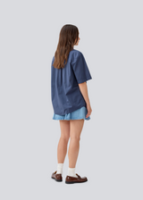 Shortsleeved shirt with a loose fit. MaudeMD SS shirt has cheast pocket, shirt collar and a button closure in front.