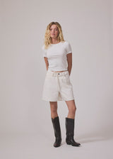 White denim shorts with wide legs in cotton denim. Naomamd solid shorts have a high waist, front and back pockets, and a tie band at the waist.