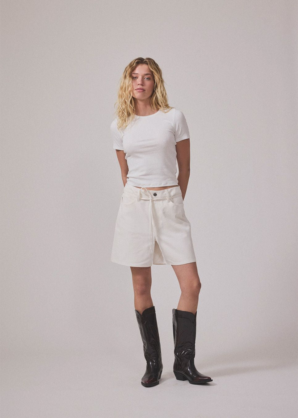 White denim shorts with wide legs in cotton denim. Naomamd solid shorts have a high waist, front and back pockets, and a tie band at the waist.