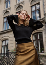 Fine black knit jumper in a drapy quality. TomMD o-neck has a slightly cropped length with long, flared sleeves. Ribknit on neckline and hem.