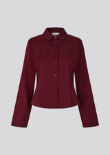 Classic fitted shirt in a cotton mix in a beautiful dark red color/burgundy. ToveMD shirt has a collar, button closure in front and long wide sleeves. The color matches the shirt in the model picture.