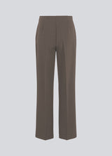 Classic pants in brown with pressfolds and straight legs. Nelli pants are closed by an hidden zipper at the side with an elastic waistband for a more comfortable fit. 