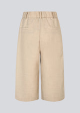 Long shorts with pleats in beige. Galemd 2 long shorts have an elastic waist, fly and side pockets.