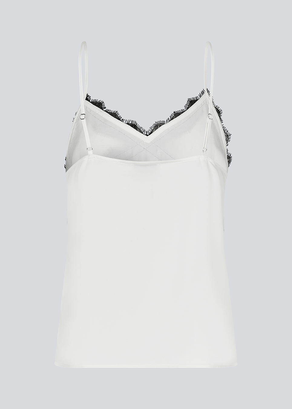 Satin top with a soft drape in white with black lace. TenjaMD top is detailed with lacing on the front and has thin straps.