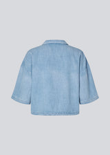 Light short-sleeve shirt in cotton denim. The AlvarMD Shirt is short and relaxed with a collar, V-neckline, and button closure. A casual and modern shirt, perfect for both everyday wear and light summer looks.