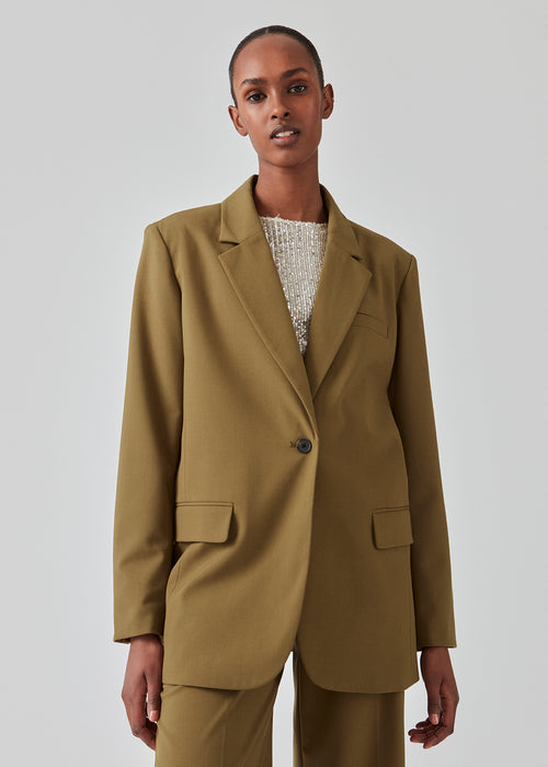 Oversized blazer with a drapy fit. AnkerMD blazer has collar and notch lapels with a single button closure. Flap welt front pockets. Slits on cuffs and single back vent. Lined.  The model is 177 cm and wears a size S/36. Style the blazer with matching pants in the same color: AnkerMD pants