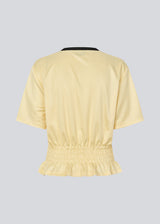 T-shirt with Brazil logo and scrunch detailing at the waist. The AnsgarMD T-Shirt features contrast trim on the round neckline, short sleeves, and a ruffled hem. A feminine and modern T-shirt, perfect for relaxed yet stylish everyday looks.