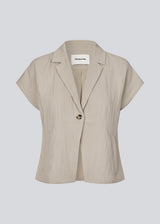 Short-sleeved blazer vest with a notched collar. The BenittaMD Vest features a relaxed, waist-focused fit, side pockets, and a single-button closure – the lightweight fabric creates a modern, effortless look, perfect worn alone or layered for a sharp, fashion-forward style.