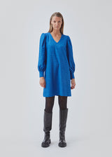 Minidress in blue with long volume sleeves a cuff. BisouMD dress has a v-neckline and an a-shaped silhouette in the body. The model is 176 cm and wears a size S/36