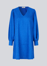 Minidress in blue with long volume sleeves a cuff. BisouMD dress has a v-neckline and an a-shaped silhouette in the body. The model is 176 cm and wears a size S/36