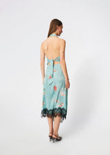 Elegant maxi dress featuring an artistic print and feminine details. Carinamd print dress is crafted from a lightweight, smooth fabric with a high halterneck neckline that fastens at the back of the neck and a self-tie belt at the waist to define the silhouette. The long, flowing fit is finished with a contrasting lace trim at the hem, adding a refined and romantic touch. A standout dress, perfect for summer parties, weddings, and other special occasions.