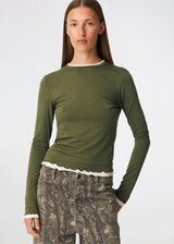 Long-sleeved T-shirt crafted from a soft and comfortable fabric. CiljaMD LS T-shirt features a fitted silhouette with a crew neckline and contrasting trims at the neckline, cuffs, and hem, creating a layered look. The delicate lettuce-edge finish adds a feminine touch, making it perfect to wear on its own or layered under knitwear, shirts, or jackets.