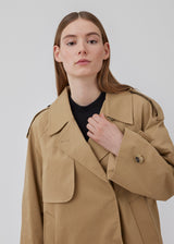 Short trench coat in beige in a cotton quality with concealed buttons down the front. Clara jacket has an oversized silhouette and classic details. Lined.