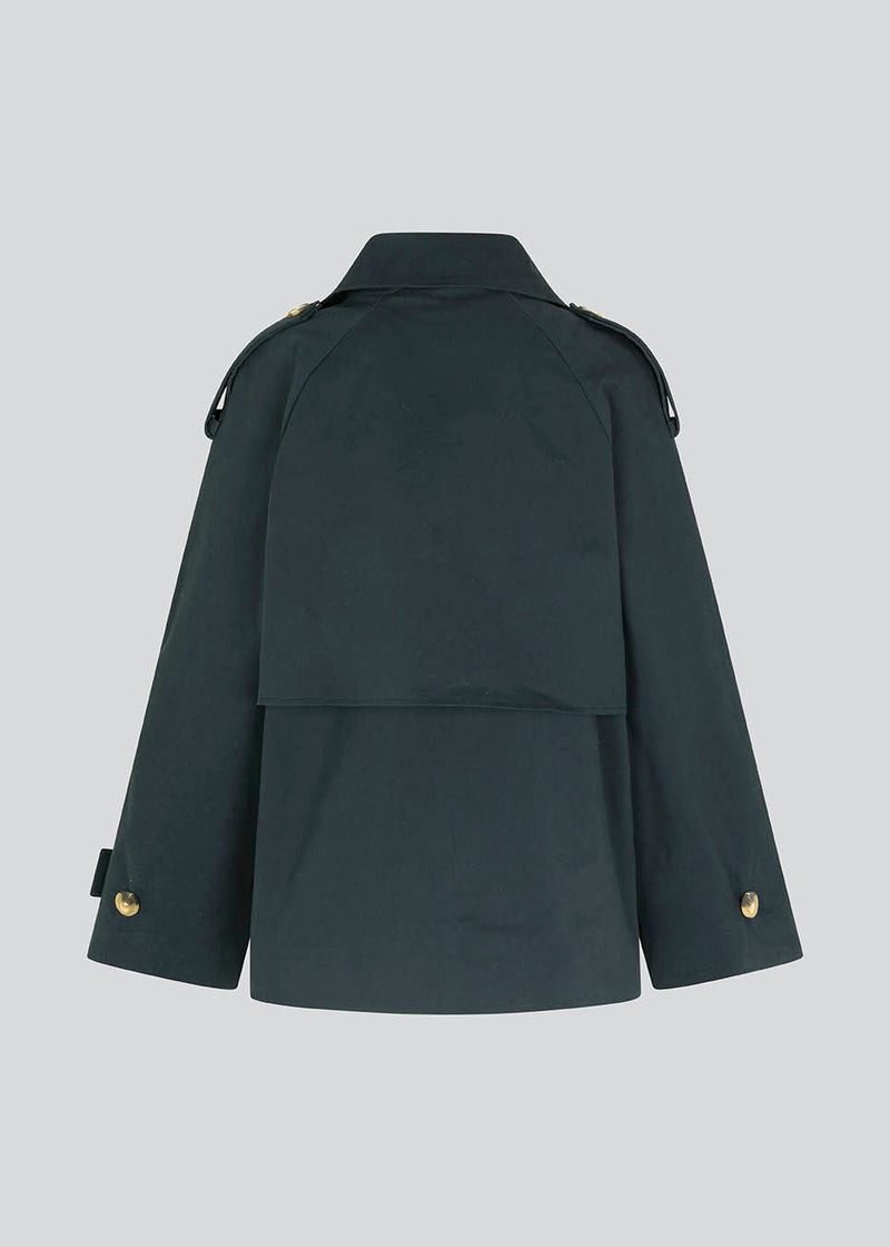 Short trench coat in dar blue in a cotton quality with concealed buttons down the front. Clara jacket has an oversized silhouette and classic details. Lined.