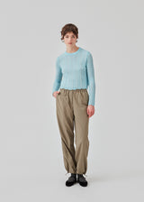 Knitted top in light blue with eyelet pattern in a light quality with wool. CordellMD short o-neck has a relaxed and cropped fit with long sleeves with wavy trims. The model is 175 cm and wears a size
