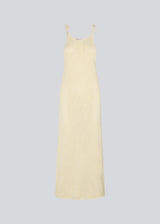 Open knit dress in beige in organic cotton. DariaMD dress has a slim fit with a long skirt, and straps that ties over the shoulder. The model is 177 cm and wears a size S/36.