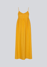 DarrelMD long dress in yellow is designed in a linen mix with a figure-hugging top with a v-neckline, spaghetti straps with adjustable ties on the back, and a loose skirt. Lined. The model is 177 cm and wears a size S/36.