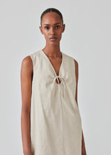Short dress in a linen blend with an A-line silhouette. DaynaMD dress is sleveless, and features a deep v-neckline with cut out details and ties. The model is 177 cm and wears a size S/36.