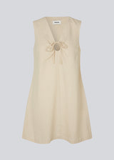 Short dress in a linen blend with an A-line silhouette. DaynaMD dress is sleveless, and features a deep v-neckline with cut out details and ties. The model is 177 cm and wears a size S/36.