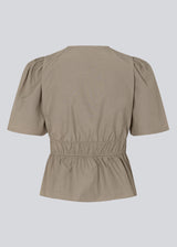 Beige top made from a cotton mix with short, slightly puffed, sleeves, and a deep v-neckline. DeenMD top has a flattering ruched detail below the chest and at the waist. The model is 177 cm and wears a size S/36.