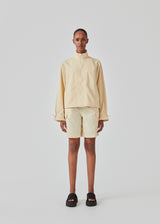 Cargo shorts in the color Pale Sun in nylon with wide legs. DilaraMD shorts have an elasticated waistband and two large patch pockets on the sides. The model is 177 cm and wears a size S/36.