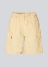 Cargo shorts in the color Pale Sun in nylon with wide legs. DilaraMD shorts have an elasticated waistband and two large patch pockets on the sides. The model is 177 cm and wears a size S/36.