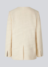 DimeMD blazer is designed in a textured cotton blend with lining. The blazer is collarless but has an asymmetrical wrap detail with a single visible button. The model is 177 cm and wears a size S/36. Style the blazer with matching shorts: DimeMD shorts.
