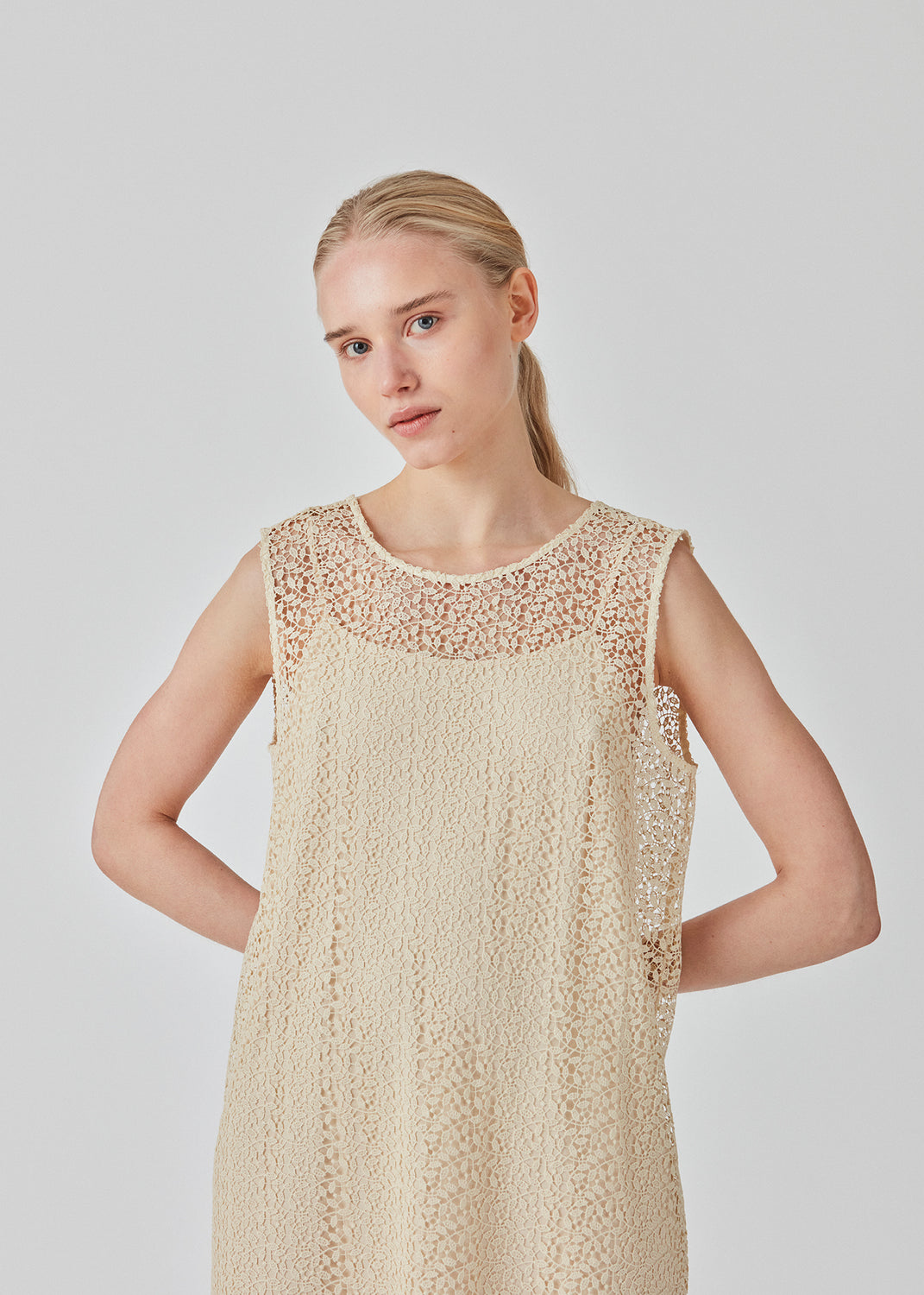 Sleeveless dress in a short length cut from a lace material. DionaMD dress has a round neck in front and a deep neckline in the back. The model is 177 cm and wears a size S/36.