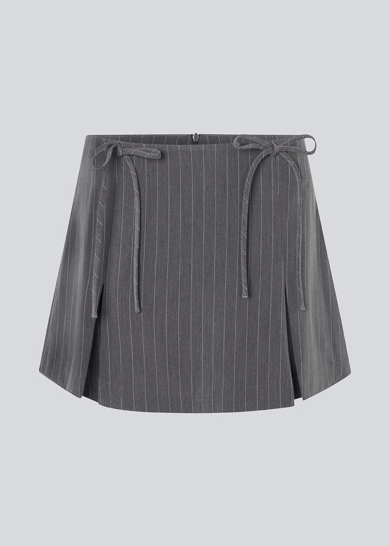 Short skirt in grey pinstripe with bows and box pleats. EmiliaMD bow skirt has an invisible zipper at the back and a cute bow detail in front.<br>