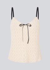Cute Loose top is in light beige/white soft lace material. EmiliaMD lace top has small adjustable black straps and a black bow detail in front.