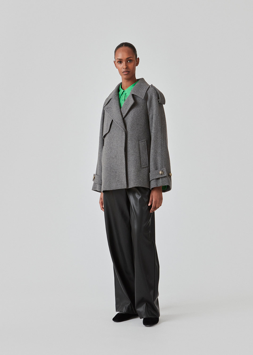 Cropped double-breasted wool coat with hidden buttons. EsmundMD jacket, in the colot Dark Grey Melange, has classic coat details with raglan sleeves and an high yoke at the back. Lined. The model is 175 cm and wears a size S/36.