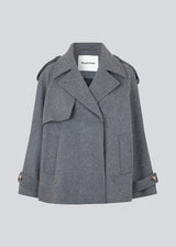 Cropped double-breasted wool coat with hidden buttons. EsmundMD jacket, in the colot Dark Grey Melange, has classic coat details with raglan sleeves and an high yoke at the back. Lined. The model is 175 cm and wears a size S/36.