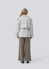 Cropped double-breasted wool coat in light grey with hidden buttons. EsmundMD jacket has classic coat details with raglan sleeves and an high yoke at the back. Lined. The model is 175 cm and wears a size S/36.