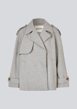 Cropped double-breasted wool coat in light grey with hidden buttons. EsmundMD jacket has classic coat details with raglan sleeves and an high yoke at the back. Lined. The model is 175 cm and wears a size S/36.