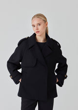 Cropped double-breasted wool coat with hidden buttons. EsmundMD jacket, in the colot Navy Sky, has classic coat details with raglan sleeves and an high yoke at the back. Lined. The model is 175 cm and wears a size S/36.