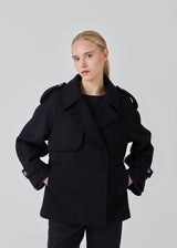 Cropped double-breasted wool coat with hidden buttons. EsmundMD jacket, in the colot Navy Sky, has classic coat details with raglan sleeves and an high yoke at the back. Lined. The model is 175 cm and wears a size S/36.