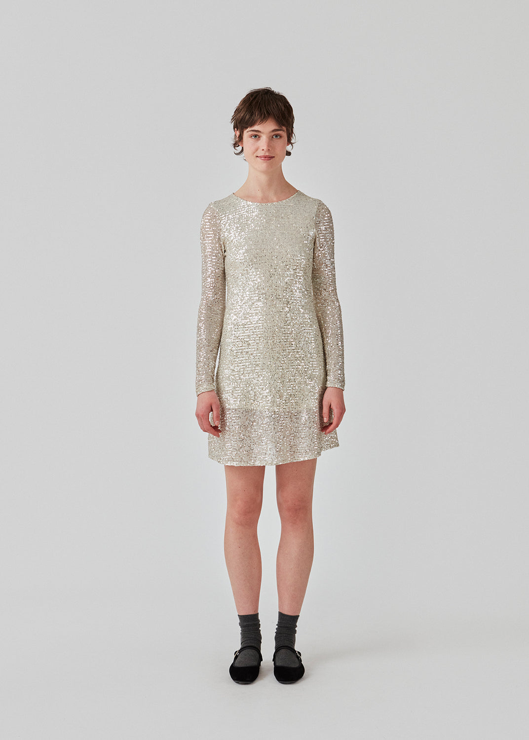 Short dress with sequins. FannieMD dress has a slim silhouette with a round neck and long sleeves, along with a keyhole opening at the back with a button for closure. The model is 175 cm and wears a size S/36.