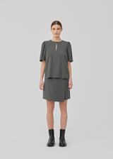Short skirt in twill. FanyaMD skirt has a wrap detail and is closed with a belt buckle in the side.
