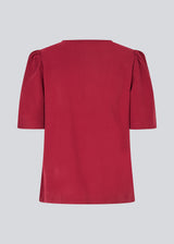 Top with short sleeves and a relaxed fit. FanyaMD SS top has an opening in front with a button closure.