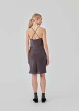 Mini dress in satin with a soft drape. FerronMD dress has a drapy neckline and narrow straps crossing at the back. Lined. The model is 175 cm and wears a size S/36.