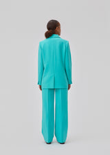 Gale pants in turquoise have a classic design. The pants have straight, wide legs with press folds, which creates an elegant look. The model is 175 cm and wears a size S/36.  Shop matching blazer: Gale blazer.