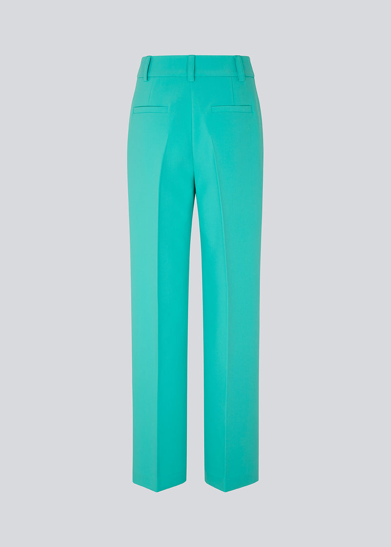 Gale pants in turquoise have a classic design. The pants have straight, wide legs with press folds, which creates an elegant look. The model is 175 cm and wears a size S/36.  Shop matching blazer: Gale blazer.