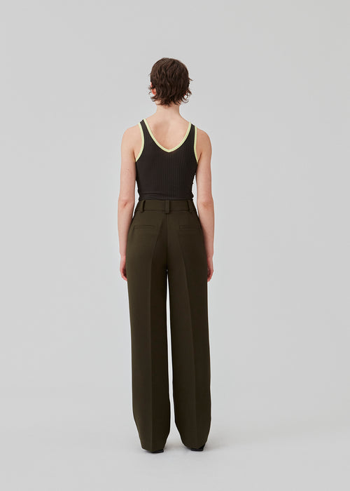 Gale pants have a classic design in dark green. The pants have straight, wide legs with press folds, which creates an elegant look. The model is 175 cm and wears a size S/36.  Style the pants with matching blazer in the same color: Gale blazer.