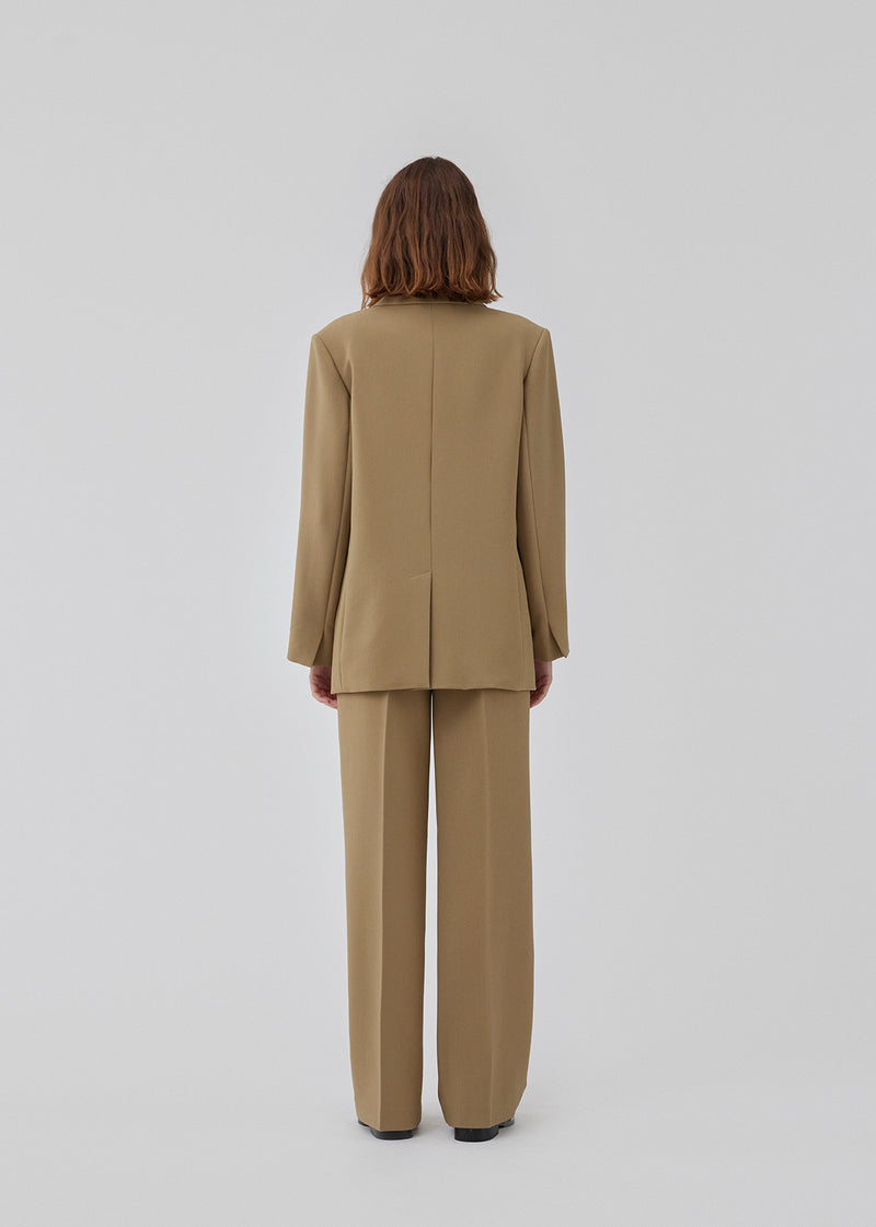 Gale pants in the color Dune have a classic design. The pants have straight, wide legs with press folds, which creates an elegant look. The model is 177 cm and wears a size S/36.
