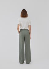 Gale pants in soft green has a classic design. The pants has straight, wide legs with pressfolds, which creates an elegant look. The model is 175 cm and wears a size S/36.<br>