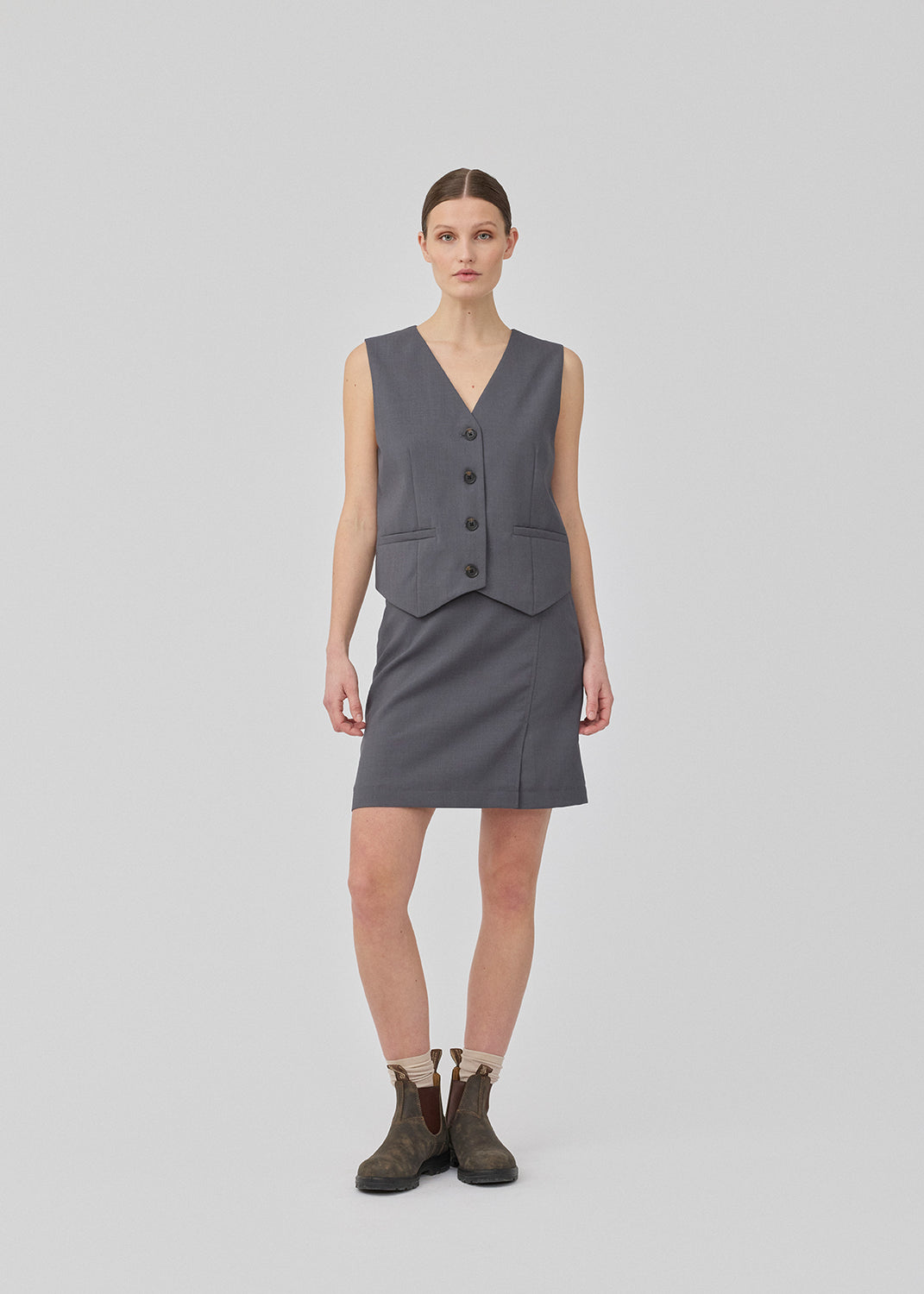 Classic A-line skirt in grey with a short length. GaleMD 2 skirt has a simple design with a hidden zipper at the side seam and a slit in front. The model is 175 cm and wears a size S/36.