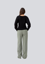 Fitted black knit in organiccotton. GalenMD short v-neck has long vide sleeves and a v-neck. The model is 177 cm and wears a size S/36.