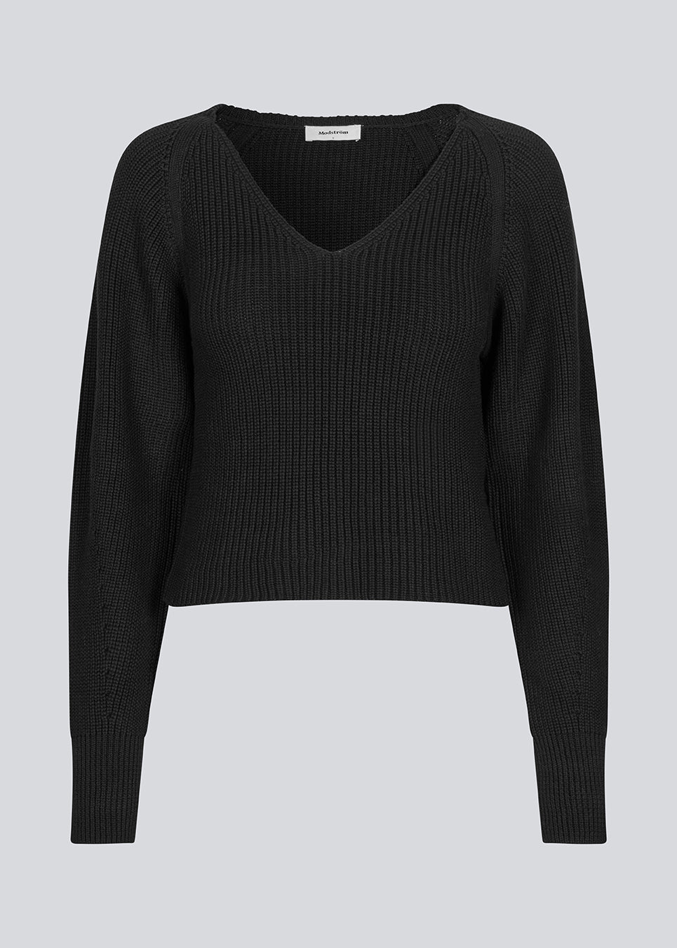 Fitted black knit in organiccotton. GalenMD short v-neck has long vide sleeves and a v-neck. The model is 177 cm and wears a size S/36.