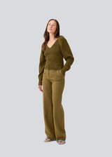 Fitted knit in dark green in organic cotton. GalenMD short v-neck has long vide sleeves and a v-neck. The model is 177 cm and wears a size S/36.