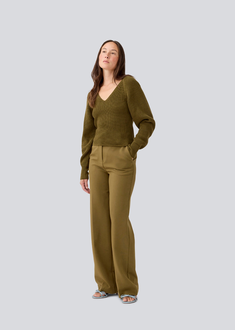 Fitted knit in dark green in organic cotton. GalenMD short v-neck has long vide sleeves and a v-neck. The model is 177 cm and wears a size S/36.